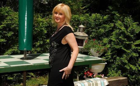 Curious blond mature Jennyfer in fancy skirt revealing her butt and spreading her legs outdoor